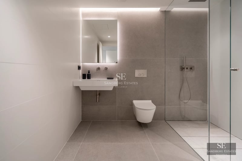 Spacious balcony with sea view. Modern furniture, wooden floor, and glass railing. Soft lighting and relaxing atmosphere.