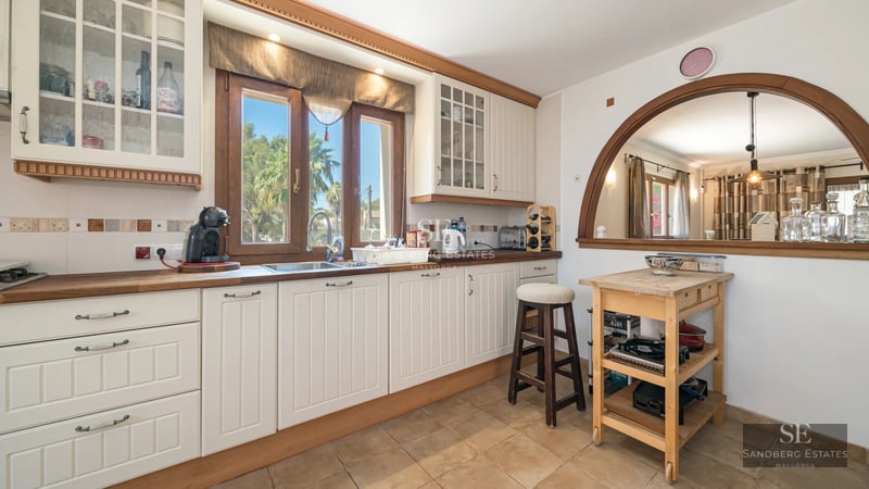 View of a modern villa featuring an infinity pool, lush garden, and minimalist architecture. Large windows illuminate the interior.