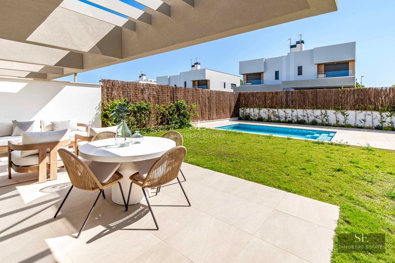 Exterior view of modern villa with pool, large windows, and lush garden. Contemporary architecture and landscape design.