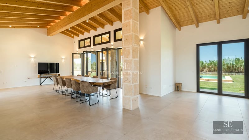 View of modern villa with infinity pool, lush garden and large windows offering panoramic views. Minimalist design.