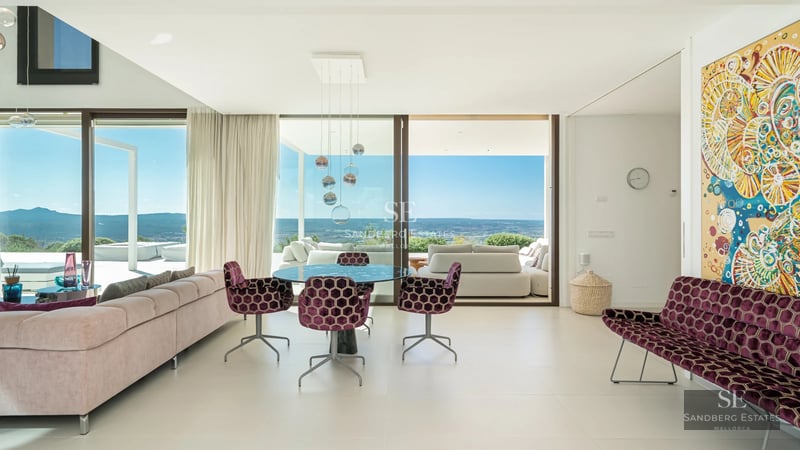 Exterior view of a modern villa featuring an infinity pool, sun loungers, and lush garden. Minimalist architecture with expansive windows.