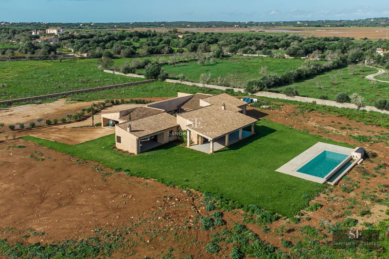 Exterior of a modern villa with a pool. Minimalist design, large windows, reflecting pool and lush garden.