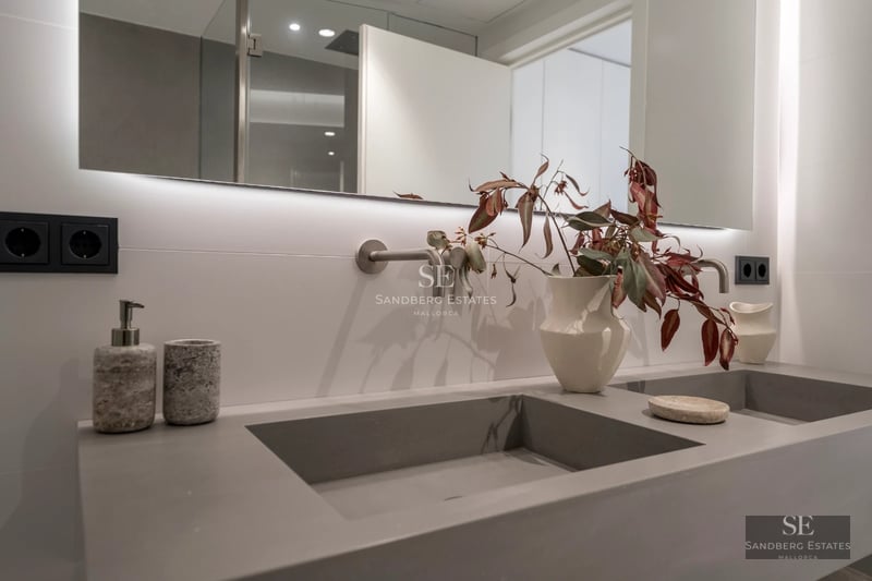 View of infinity pool with sun loungers, umbrellas, and lush greenery. Modern and elegant design. Sunny day.