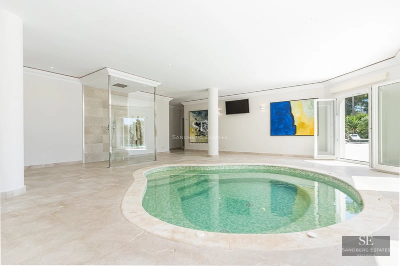 Exterior view of a modern villa featuring an infinity pool, lush garden, and spacious terraces. Minimalist and elegant architectural design.