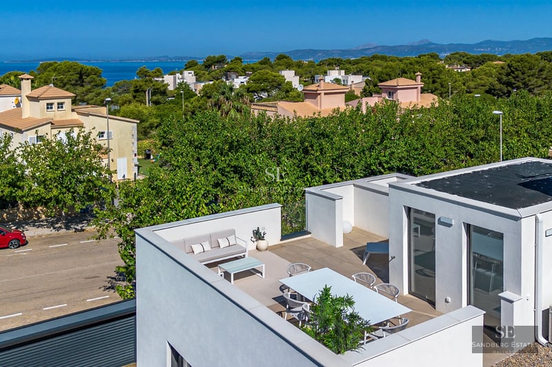 Exterior view of a modern villa with a pool, garden, and terrace. Minimalist design, clean lines, and large panoramic windows.