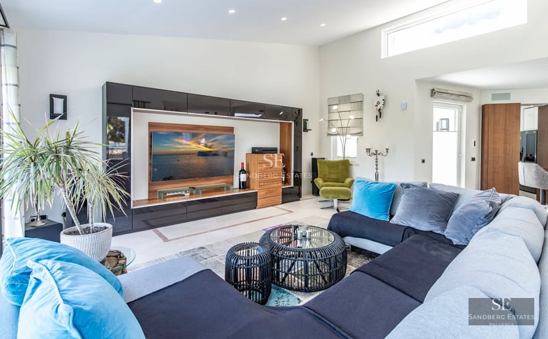 Expansive terrace with infinity pool, lounge chairs, panoramic views, and modern architecture featuring large windows.