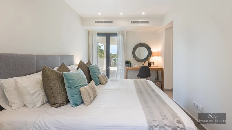 Spacious balcony with panoramic sea views. Modern furniture, light wood floors, and glass railings. Abundant natural lighting.