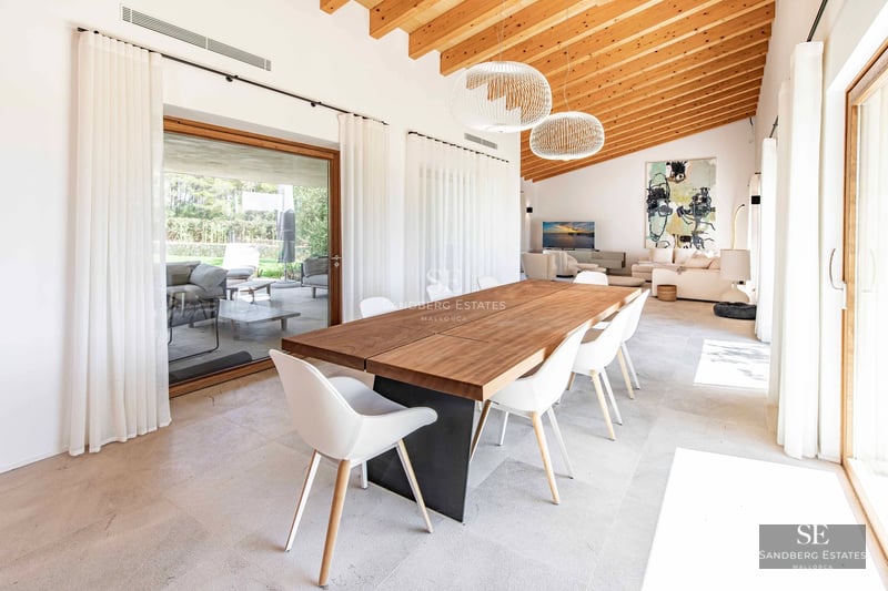 Spacious living room with floor-to-ceiling windows, modern fireplace, designer sofas and garden view. Natural lighting and luxurious finishes.