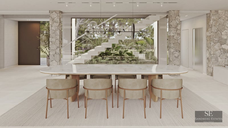 Elegant dining area featuring a white marble table, stone pillars, and views of a designer staircase and lush garden.