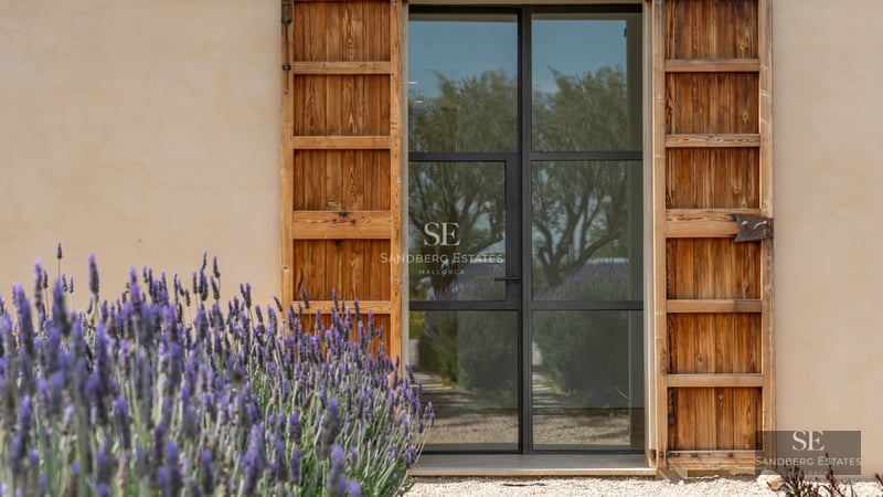 Large swimming pool surrounded by lush greenery and a modern house with large windows. Sleek and minimalist design.