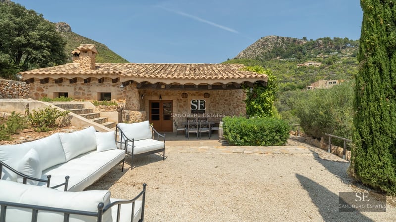 Spacious terrace with pool and views of greenery. Modern design with wood and natural stone. High-end outdoor furniture.