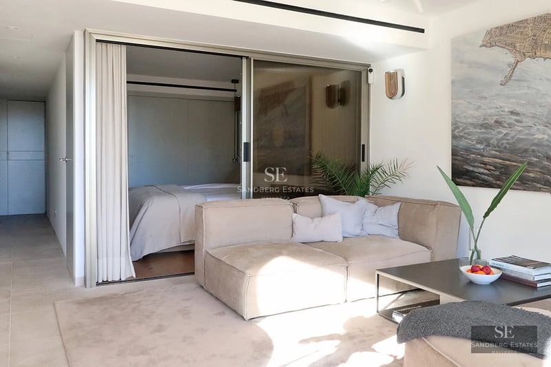 Exterior view of a modern villa featuring a pool, sun loungers, and lush vegetation. Minimalist architecture, soft lighting.