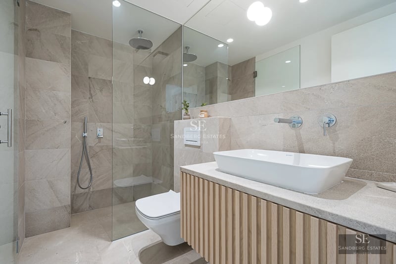 Spacious balcony with panoramic sea views. Modern and elegant furniture. Glass railing and light wood flooring.