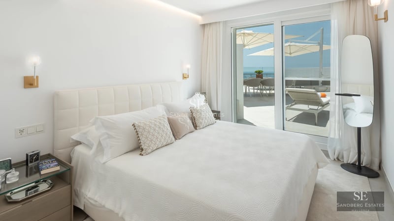 Bright interior with balcony and sea view. Modern design, wood flooring, and abundant natural light.