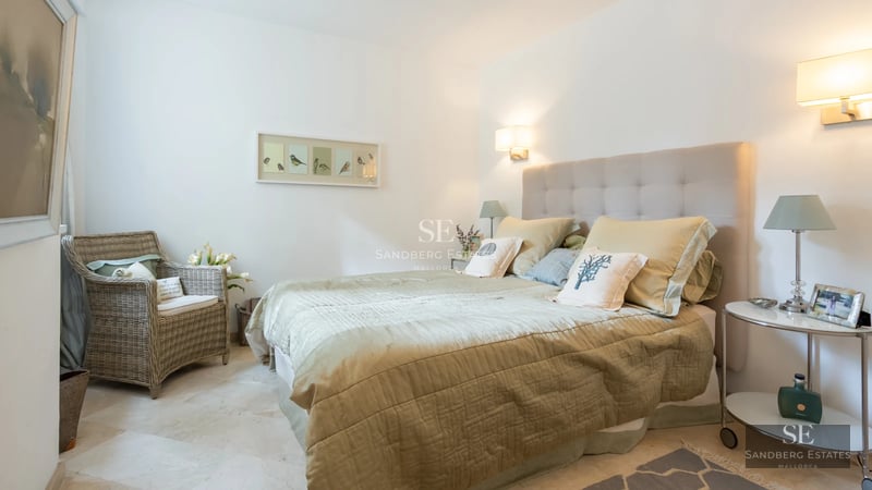 Panoramic view of an infinity pool with a glass edge and sea views. Modern design with sun loungers and lush vegetation.