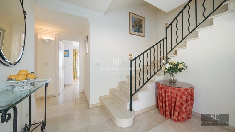 Minimalist balcony with glass railing, panoramic sea view, modern furniture and sleek design. Natural light.