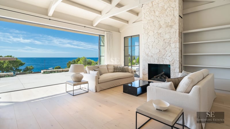 Exterior of modern villa with infinity pool. Minimalist architecture, large windows, manicured garden, sun loungers, and stylish umbrellas.