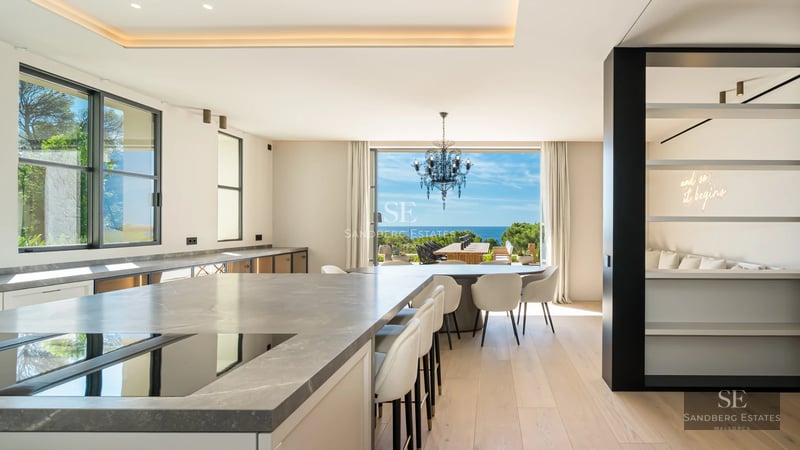 Exterior view of a luxury villa featuring a pool, large garden, and modern architecture. Warm lighting and high-quality finishes.