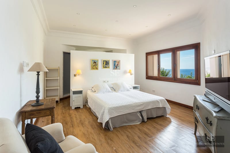 Vue extérieure d'une villa moderne avec piscine à débordement, grandes baies vitrées, jardin luxuriant et architecture contemporaine. Design élégant.