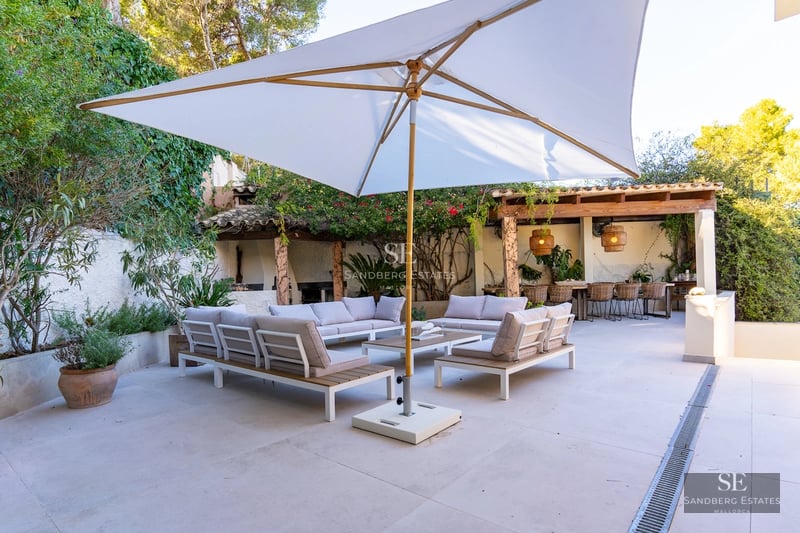 View of a luxurious villa with infinity pool, lush garden, and modern architecture. Elegant design and spacious areas.