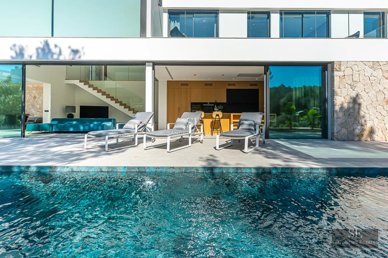 Vue piscine à débordement avec chaises longues. Design moderne, palmiers, ciel bleu. Luxe et confort. Détente au bord de la piscine.