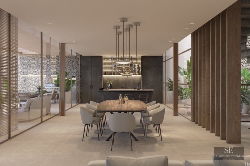 Elegant dining room featuring a wooden table, designer pendant lights, and floor-to-ceiling glass walls.