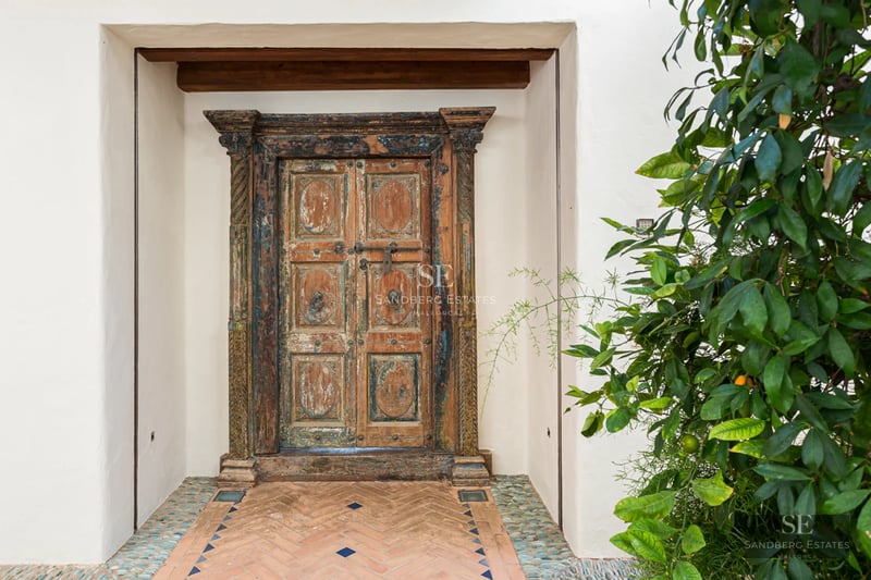 Vue panoramique d'une villa moderne avec piscine à débordement, jardin luxuriant et terrasse couverte. Design élégant et contemporain.