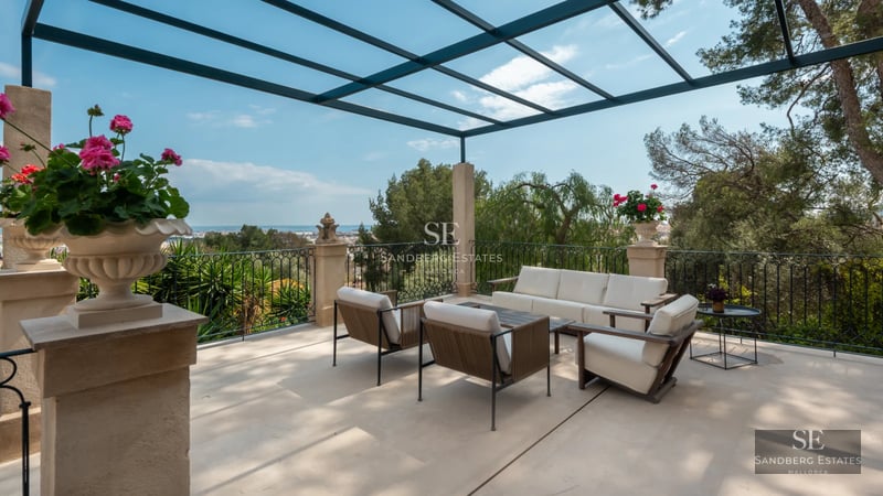 Exterior view of a modern villa featuring a pool, lush garden, and spacious terraces. Stylish design and high-quality finishes.