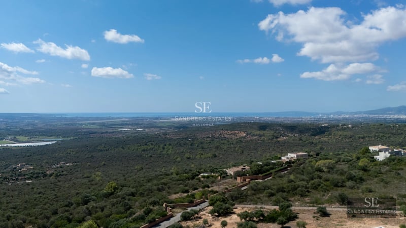 Spacious balcony with panoramic sea views. Modern design featuring glass railings and outdoor furniture. Ambient lighting.