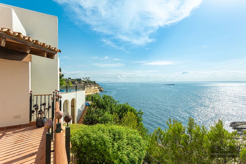 Vue extérieure d'une maison moderne avec piscine, jardin luxuriant et grandes fenêtres illuminant l'intérieur.