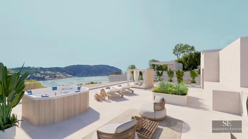 A sunny rooftop terrace with a wood-paneled jacuzzi, sun loungers, and lounge chairs overlooking a coastal bay.