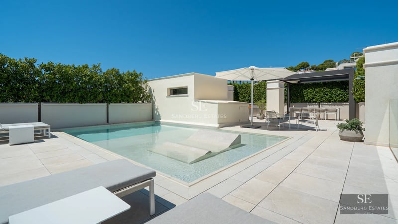 Spacious terrace with pool, sea views, modern furniture, and lush greenery. Elegant architectural design.