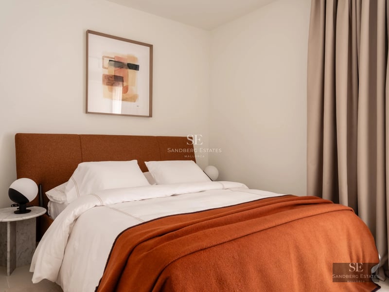 View of infinity pool with vanishing edge, manicured lawn, trees, and modern minimalist-design house in the background.