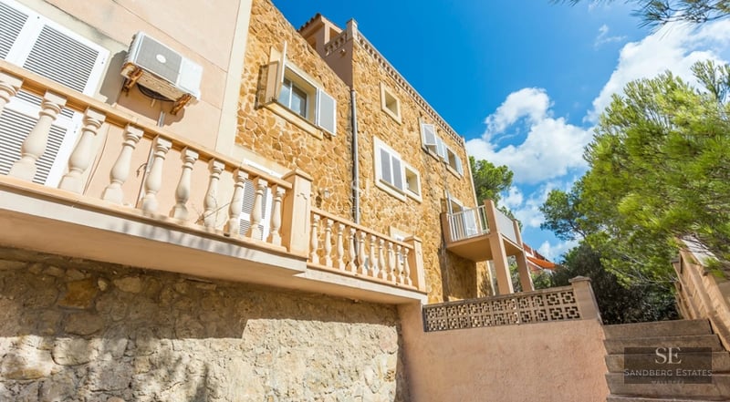 Spacious living room with floor-to-ceiling windows overlooking the sea. Modern design, natural light, neutral color palette. Wood floors and elegant furniture.