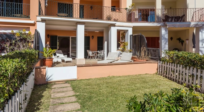 Bright living room with infinity pool, large windows, light wood floors, and modern furniture. Panoramic views.