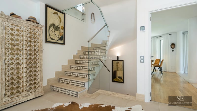 Exterior view of a modern villa featuring a swimming pool, lush garden, large windows, and designer architecture. Natural lighting.