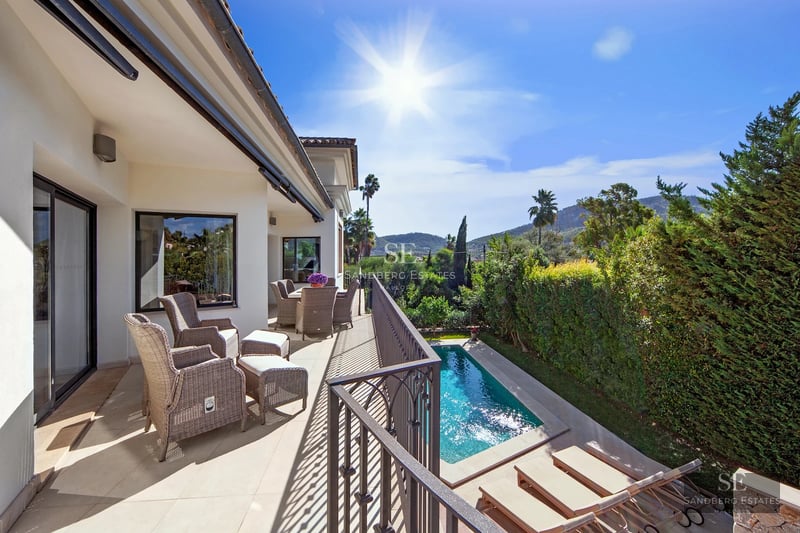 Spacious terrace with pool, sun loungers, lush greenery and unobstructed views. Modern and elegant design.