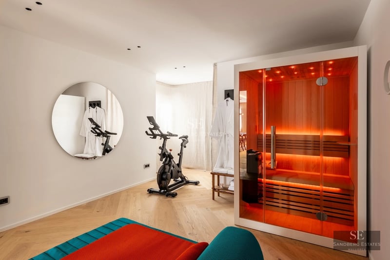 Spacious living room with fireplace, window overlooking pool and modern furniture. High-quality finishes and abundant natural light.