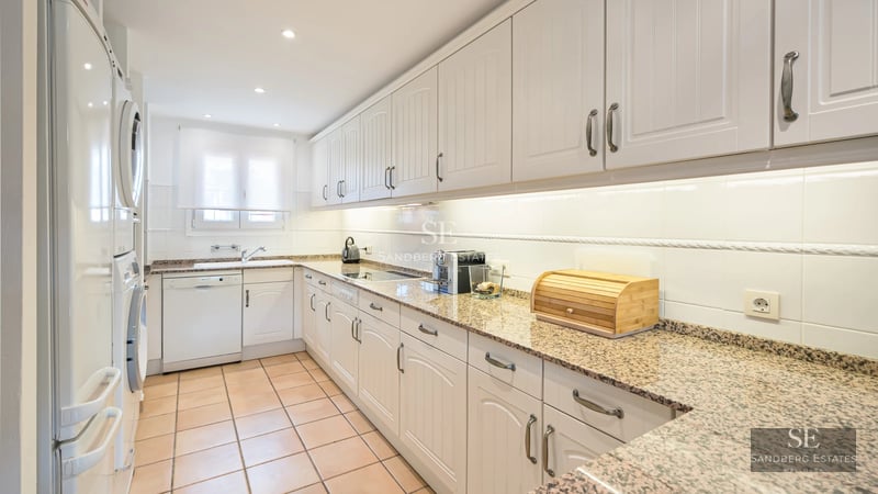 Pool view with sun loungers and lush garden. Modern architecture with large windows. Relaxing and luxurious atmosphere.