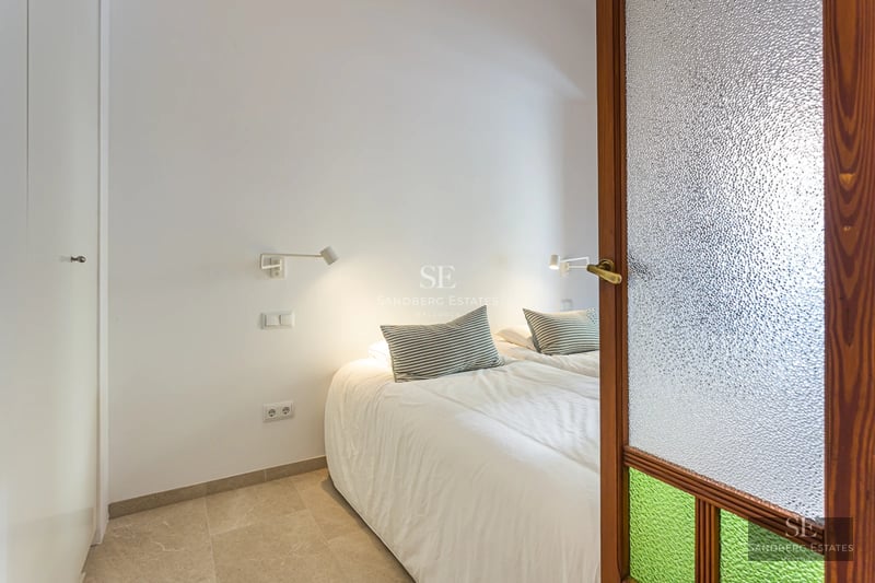 Modern apartment with glass-enclosed balcony offering panoramic sea views. Sleek design with natural light and high-quality furnishings.