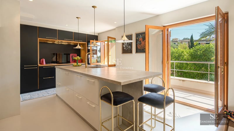 Spacious balcony with sea views. Modern furniture, light wood floors, and glass railing. Minimalist and elegant design.