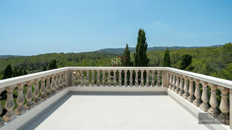 Spacious living room with floor-to-ceiling windows, light wood flooring, modern gray sofas, coffee table, and balcony access with sea view.