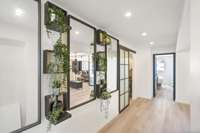 Moderner Flur mit schwarz gerahmten Spiegeln, integrierten Pflanzenregalen und hellem Echtholzboden.