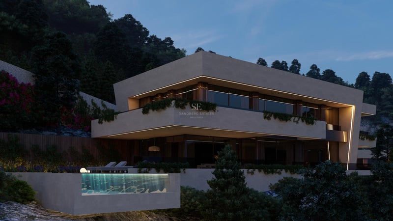 Villa sur deux niveaux avec piscine à débordement aux parois de verre devant une colline boisée au crépuscule.