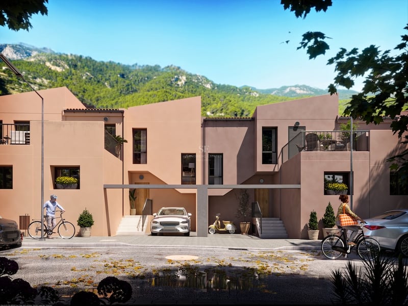 Moderna terrakottafärgade radhus mot en frodig bergskuliss med cyklister på gatan.