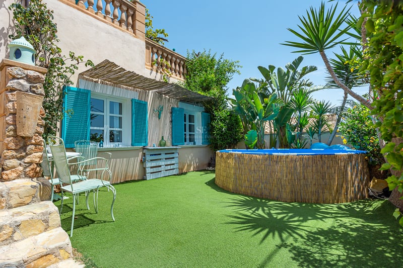 Spacious balcony with glass railing, panoramic sea view, modern outdoor furniture, and retractable awning for shade.