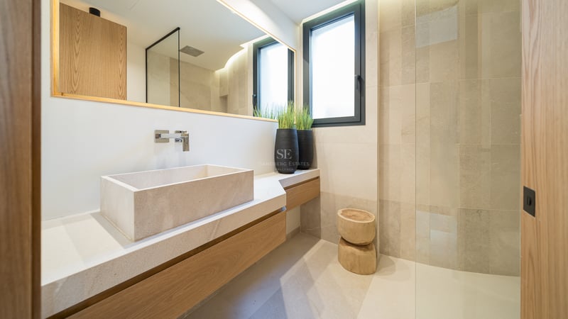 Salle de bain contemporaine avec vasque en pierre, meuble en chêne et douche à l'italienne vitrée.