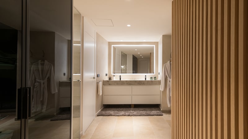 Vanité contemporaine avec plan en marbre, double vasque, miroir LED et boiseries en chêne.