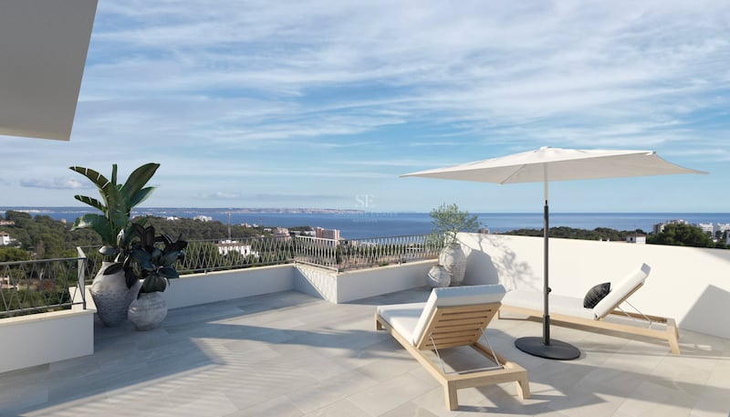 Sonnige Terrasse mit Holzliege, weißem Sonnenschirm und Panoramablick auf die Mittelmeerküste und das blaue Meer.