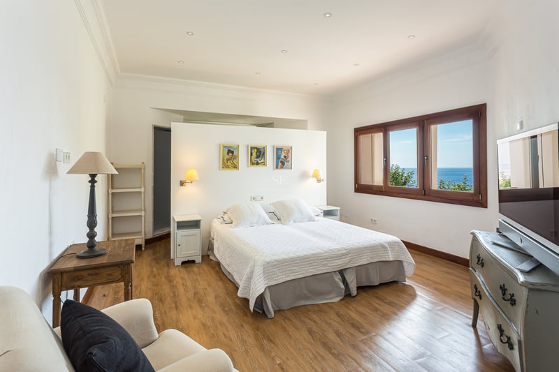 Vue extérieure d'une villa moderne avec piscine à débordement, grandes baies vitrées, jardin luxuriant et architecture contemporaine. Design élégant.